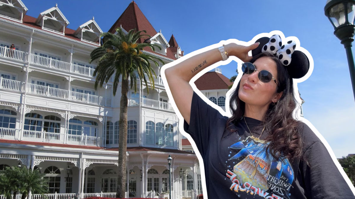 A guest in Minnie ears poses in front of Disney's Grand Floridian Resort & Spa