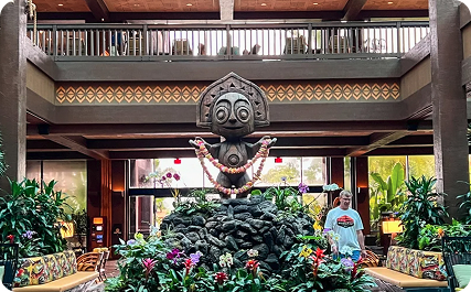 A carved tiki figure rises above tropical plants in the Polynesian's multilevel lobby