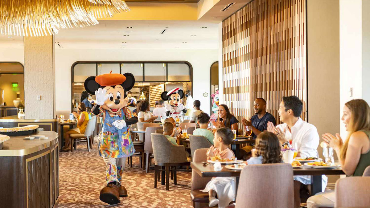 Minnie Mouse greets guests in a sunlit dining room at Disney's Riviera Resort