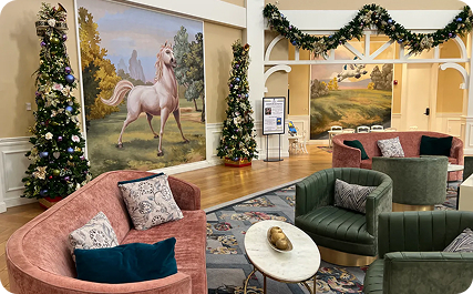 Saratoga Springs lobby seating includes green and pink sofas, horse artwork, and holiday decorations